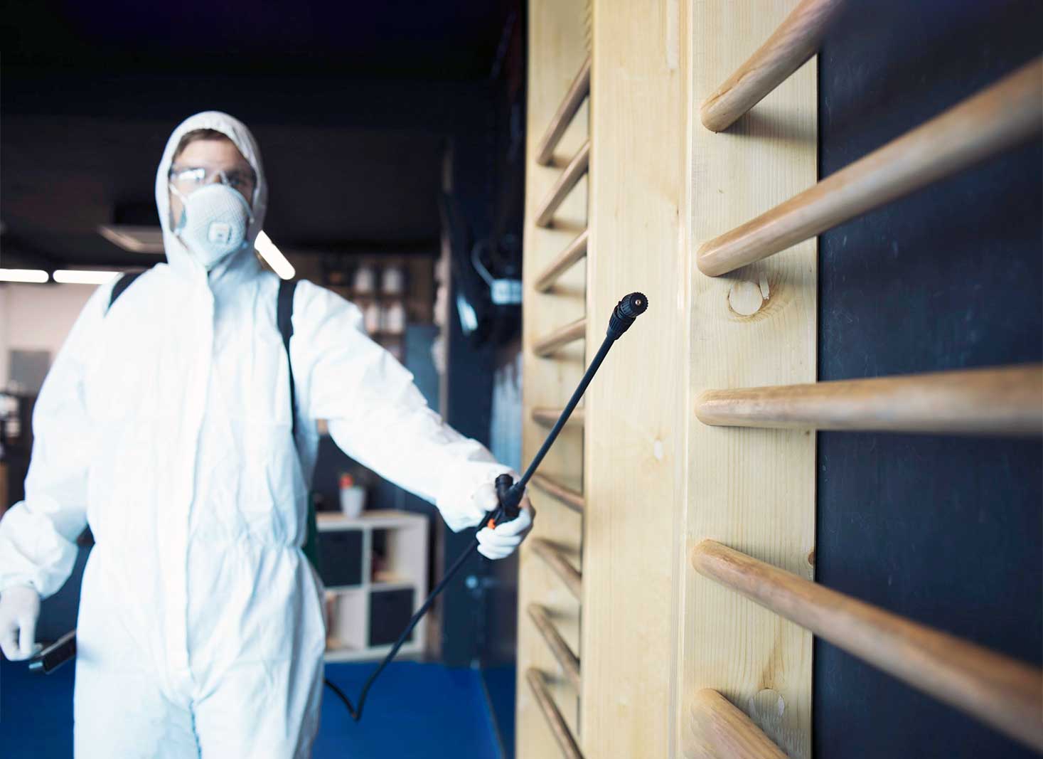 A-pest-control-technician-spraying-a-house-with-a-chemical-treatment.